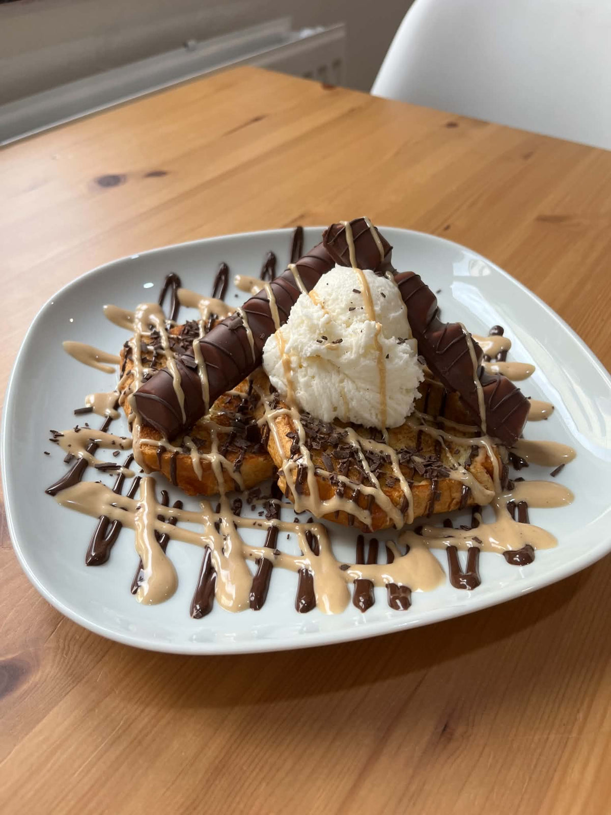Deux tranches de pain perdu Bueno avec une boule de glace vanille, morceaux de Bueno, coulis Nutella et coulis Bueno blanc à la noisette. Accompagnements servis à part.