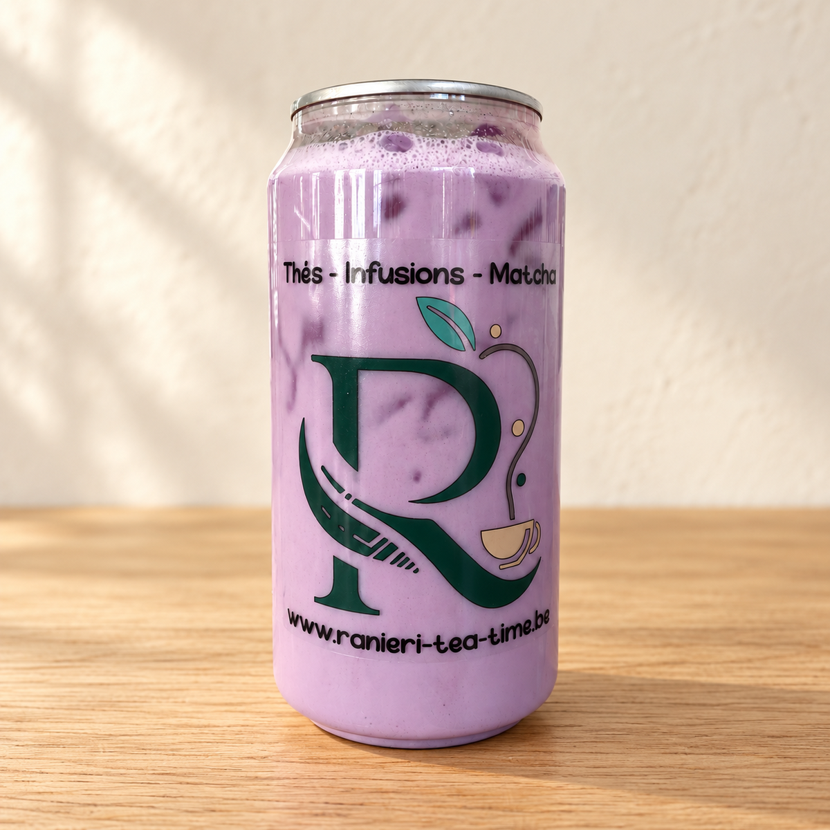 Ube latte glacé Ranieri en canette, sur une table en bois clair