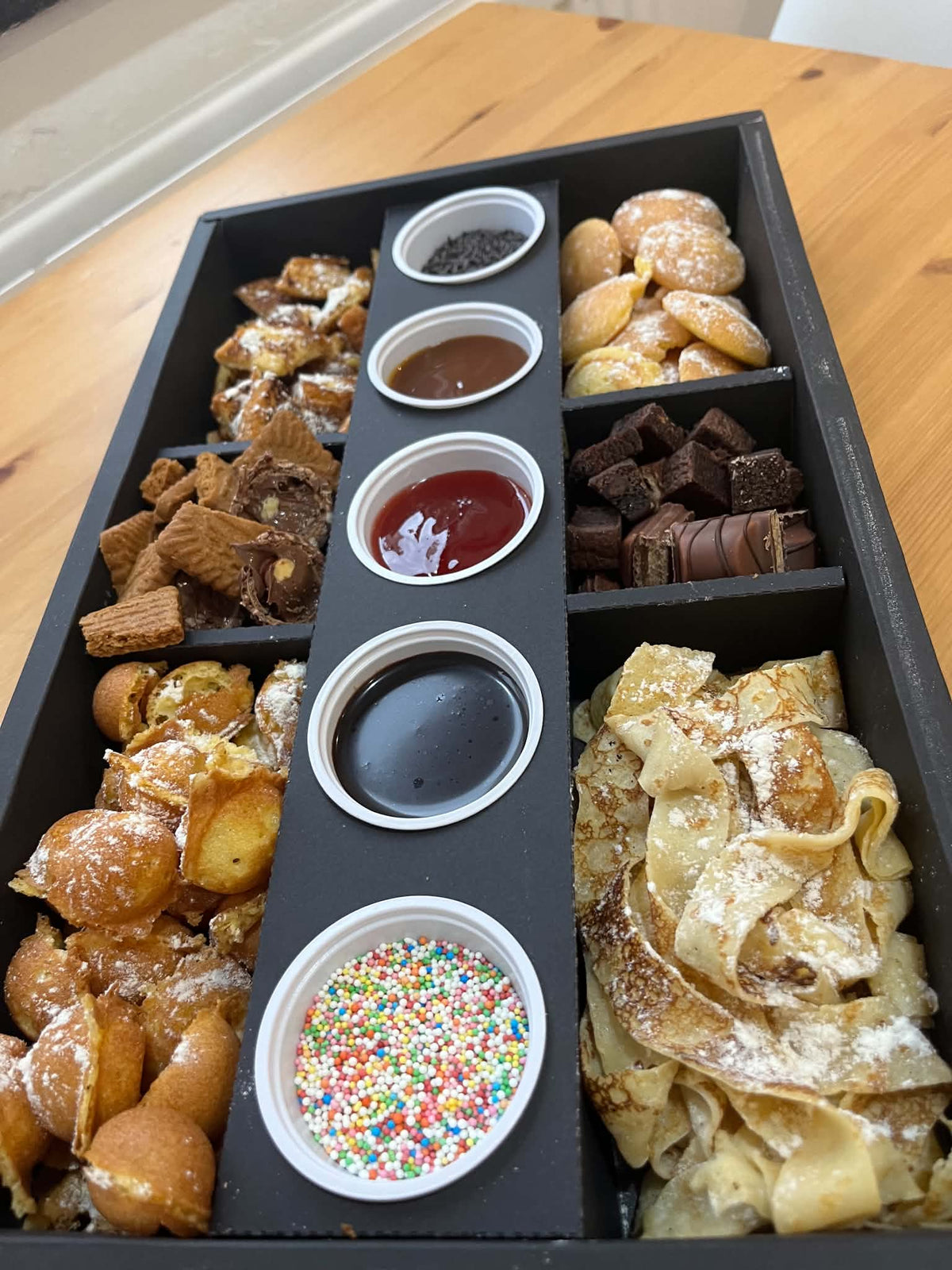 Boîte découverte Ranieri : pâtisseries et gourmandises en compartiments, coulis et vermicelles servis à part. Vue 1, exemple de présentation.