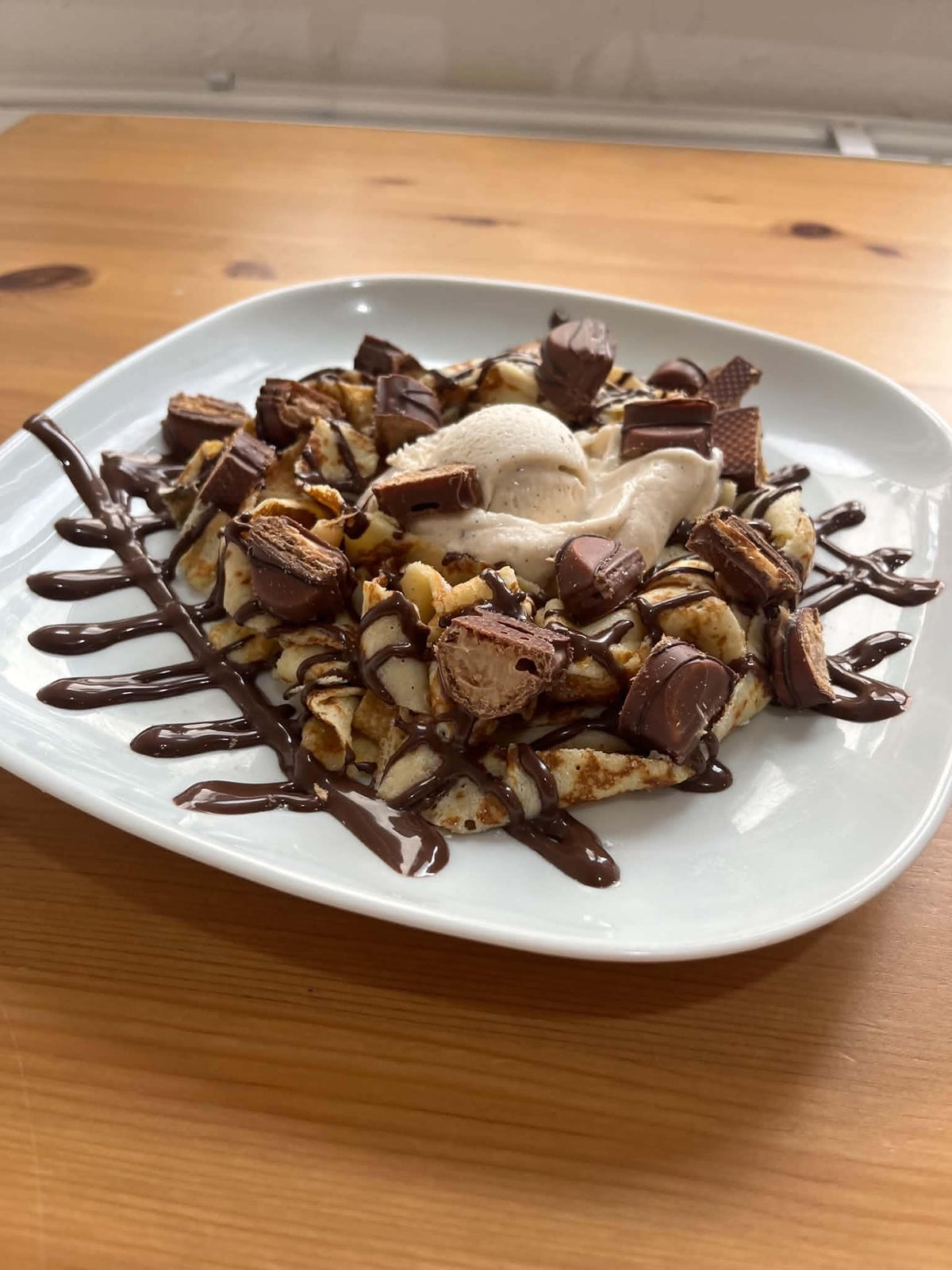 Crêpe en tagliatelles Bueno avec une boule de glace, morceaux de Bueno, coulis Nutella, coulis Bueno noisette et chantilly. Suggestion de présentation ; accompagnements servis à part.
