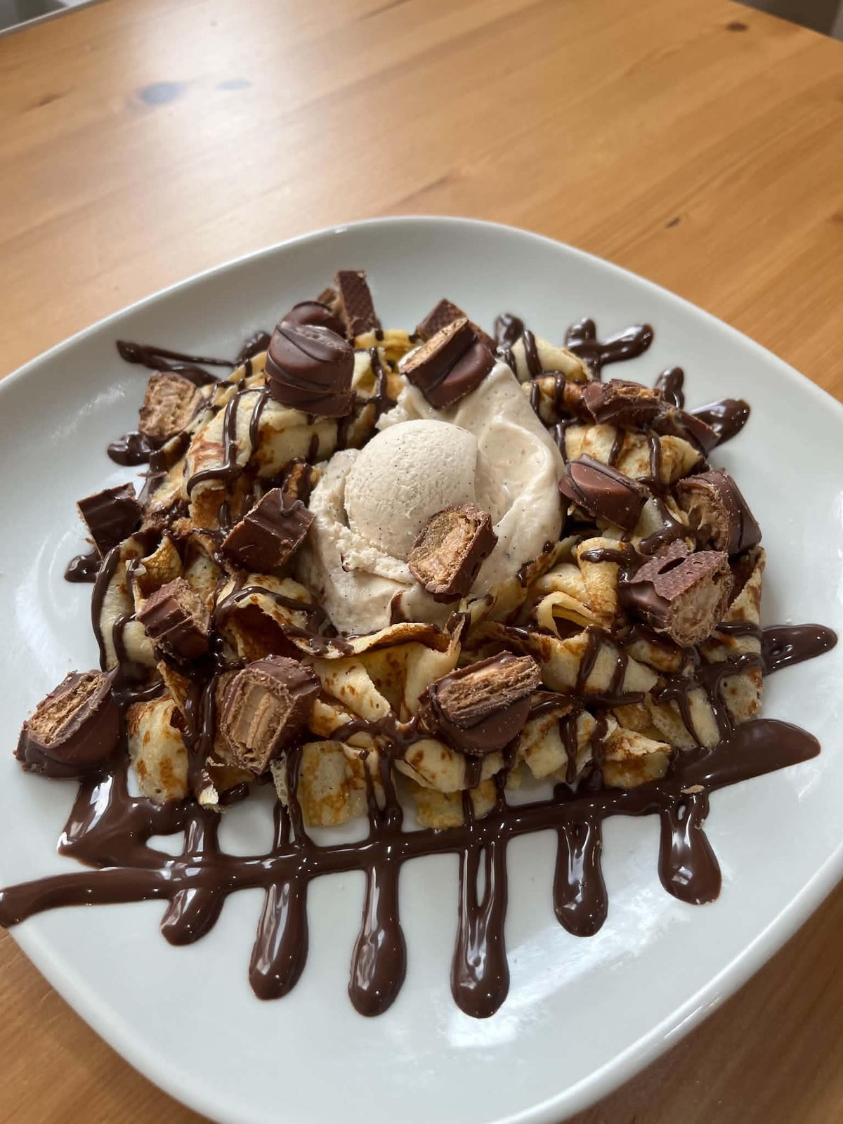 Deuxième vue de la crêpe en tagliatelles Bueno avec une boule de glace, morceaux de Bueno, coulis Nutella, coulis Bueno noisette et chantilly. Accompagnements servis à part.
