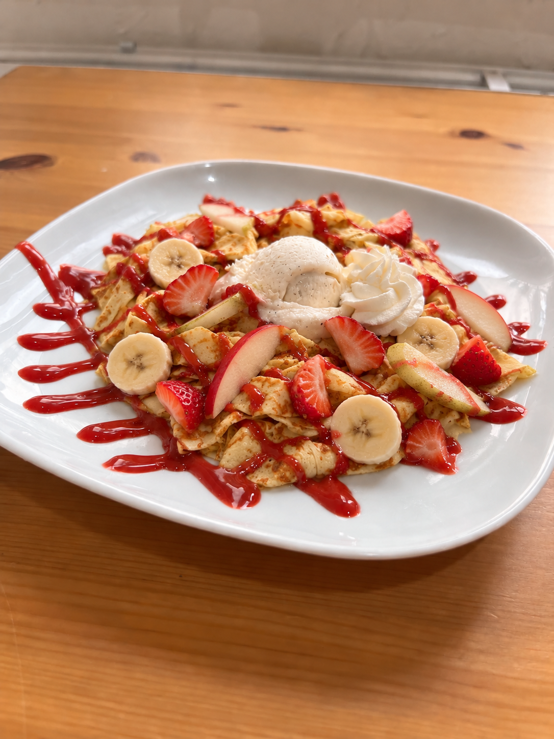 Crêpe en tagliatelles aux fruits de saison, coulis de fraise, une boule de glace vanille et chantilly. Suggestion de présentation ; accompagnements servis à part.