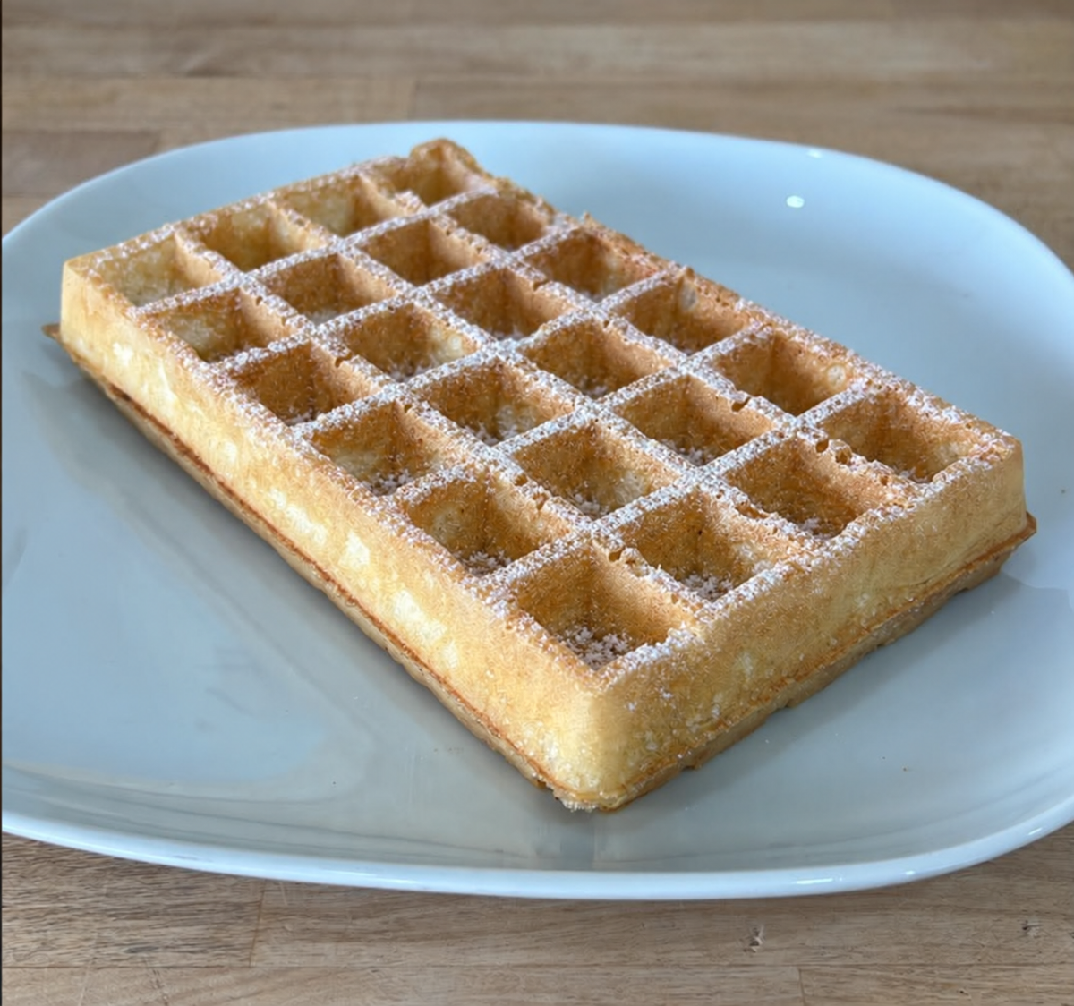 Gaufre de Bruxelles nature légèrement saupoudrée de sucre impalpable, sans accompagnement.