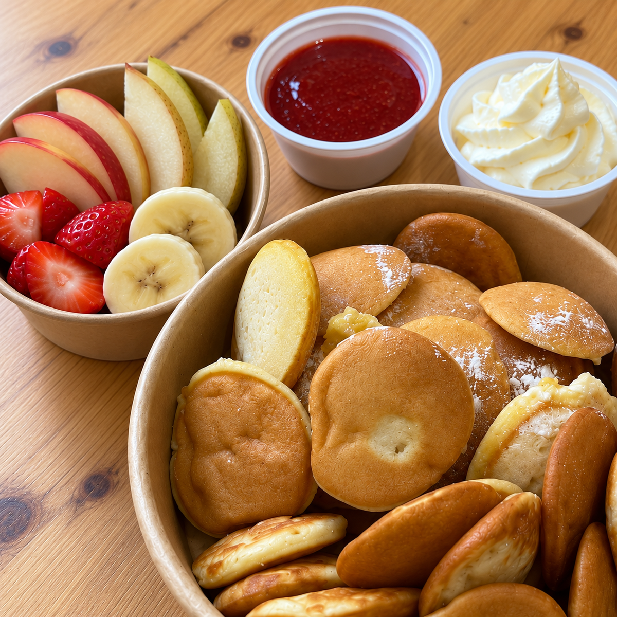 Mini pancakes fruits de saison — vue rapprochée sur table en bois, accompagnements servis à part, sans glace incluse.
